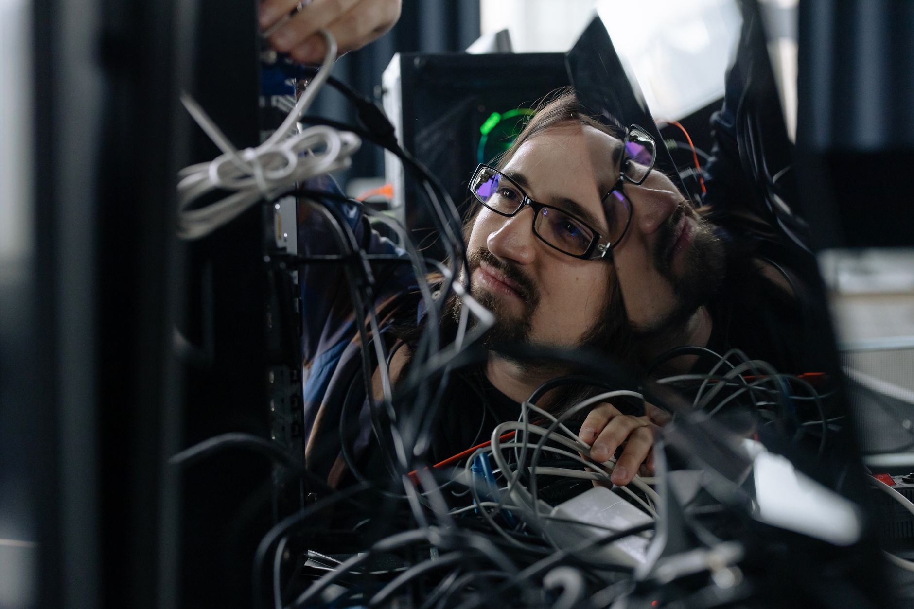 IT technician organizing cables and equipment at a workstation in an office